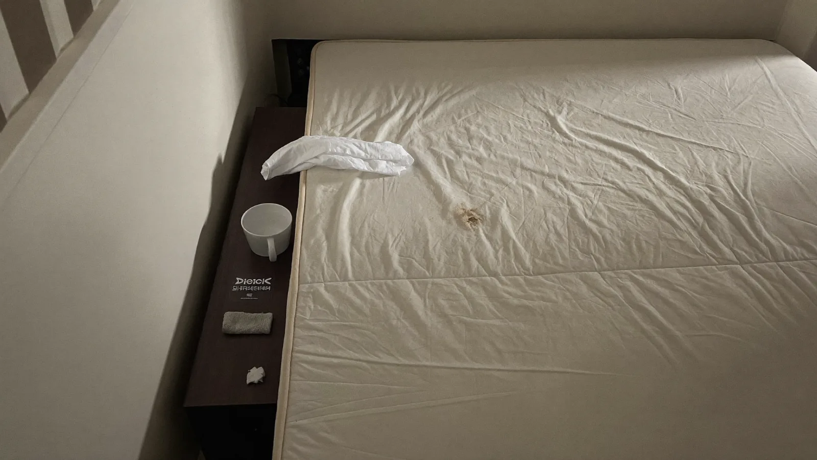 Tache de sang sur un matelas blanc, chiffon et eau froide posés à côté — illustration
