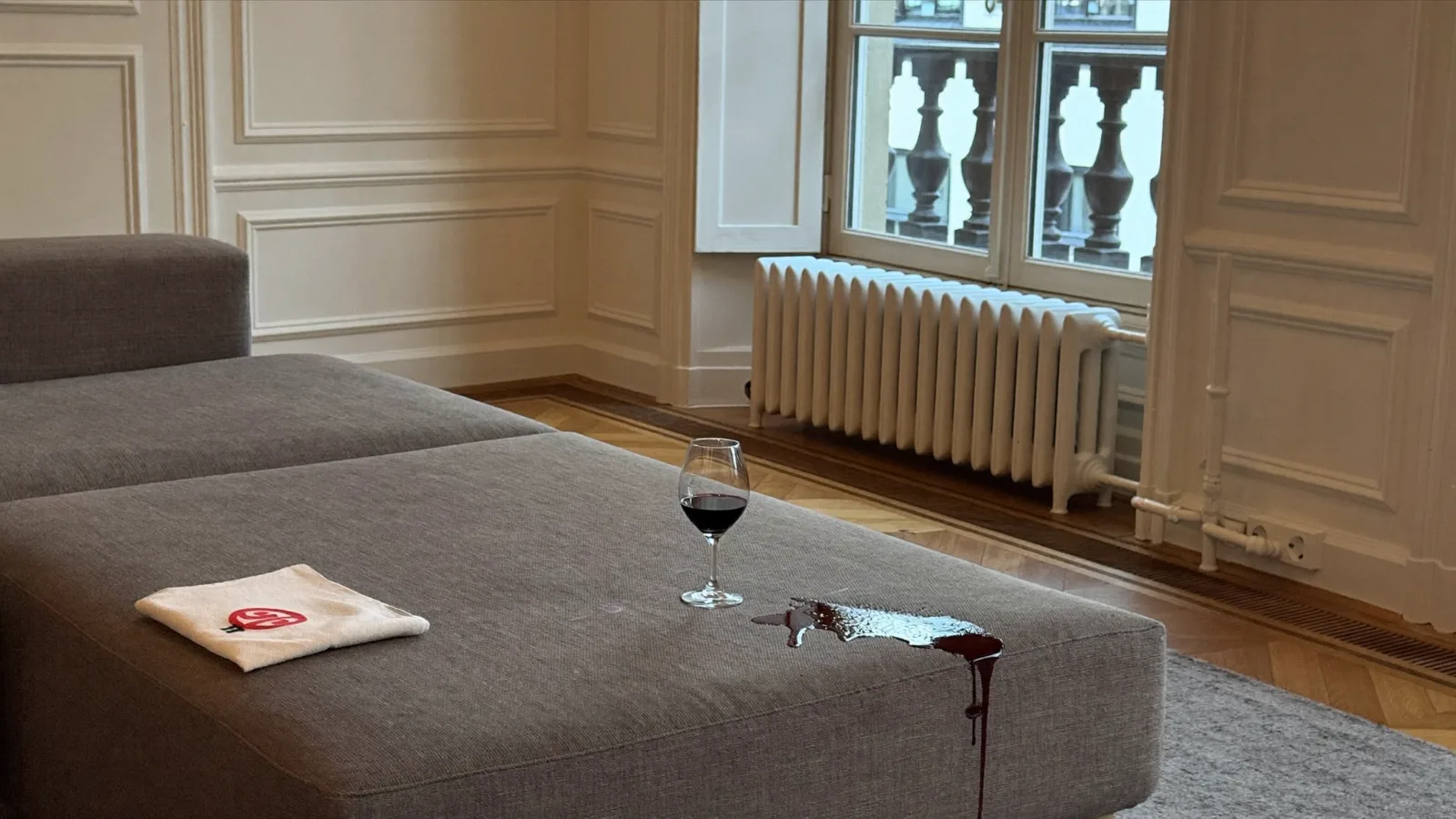 Tache de vin rouge sur canapé en tissu gris clair, verre renversé — illustration